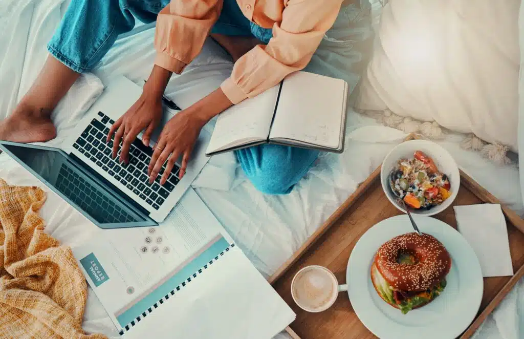 Breakfast, bed and laptop hands for work from home productivity, time management and planning finan